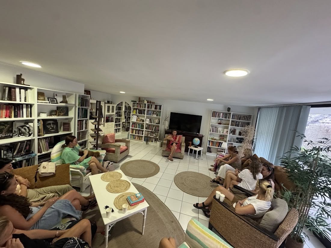 Mesa de coworking con lámpara cálida y plantas dentro de una biblioteca