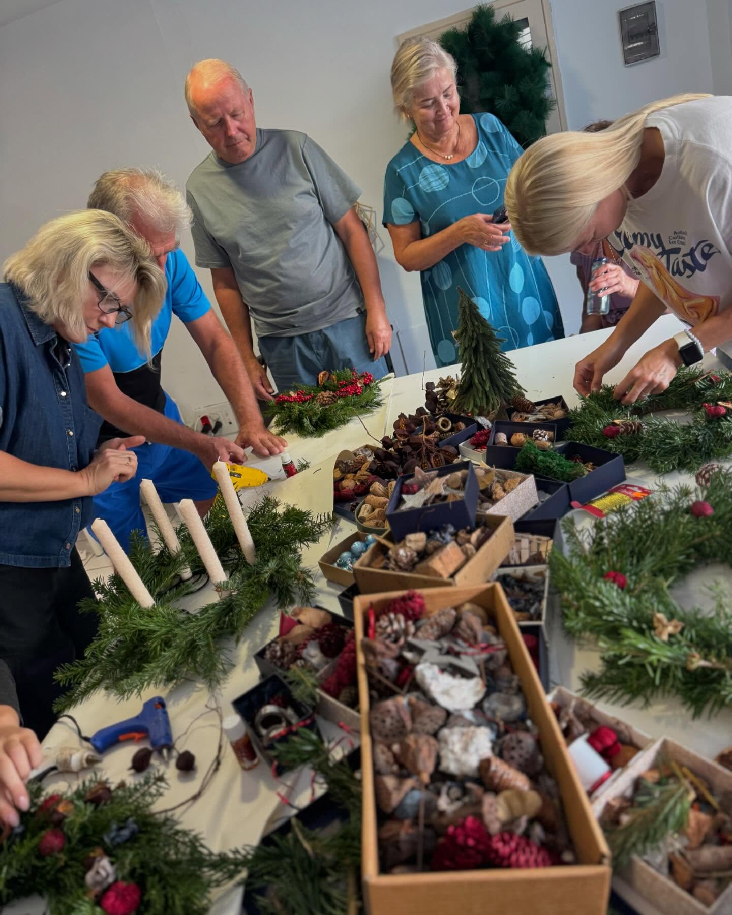 Adults crafting holiday wreaths together