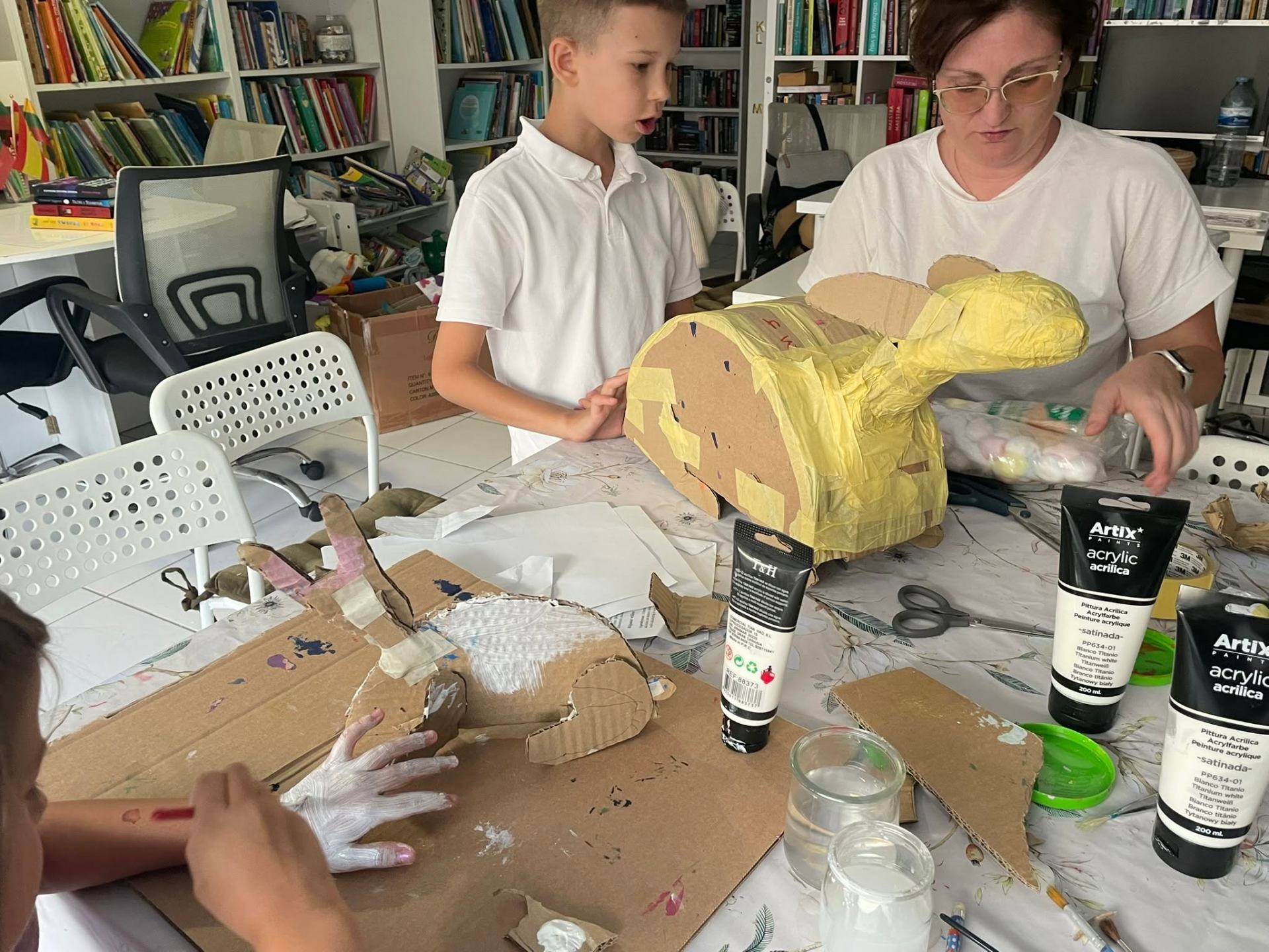 Child and teacher building a cardboard sculpture