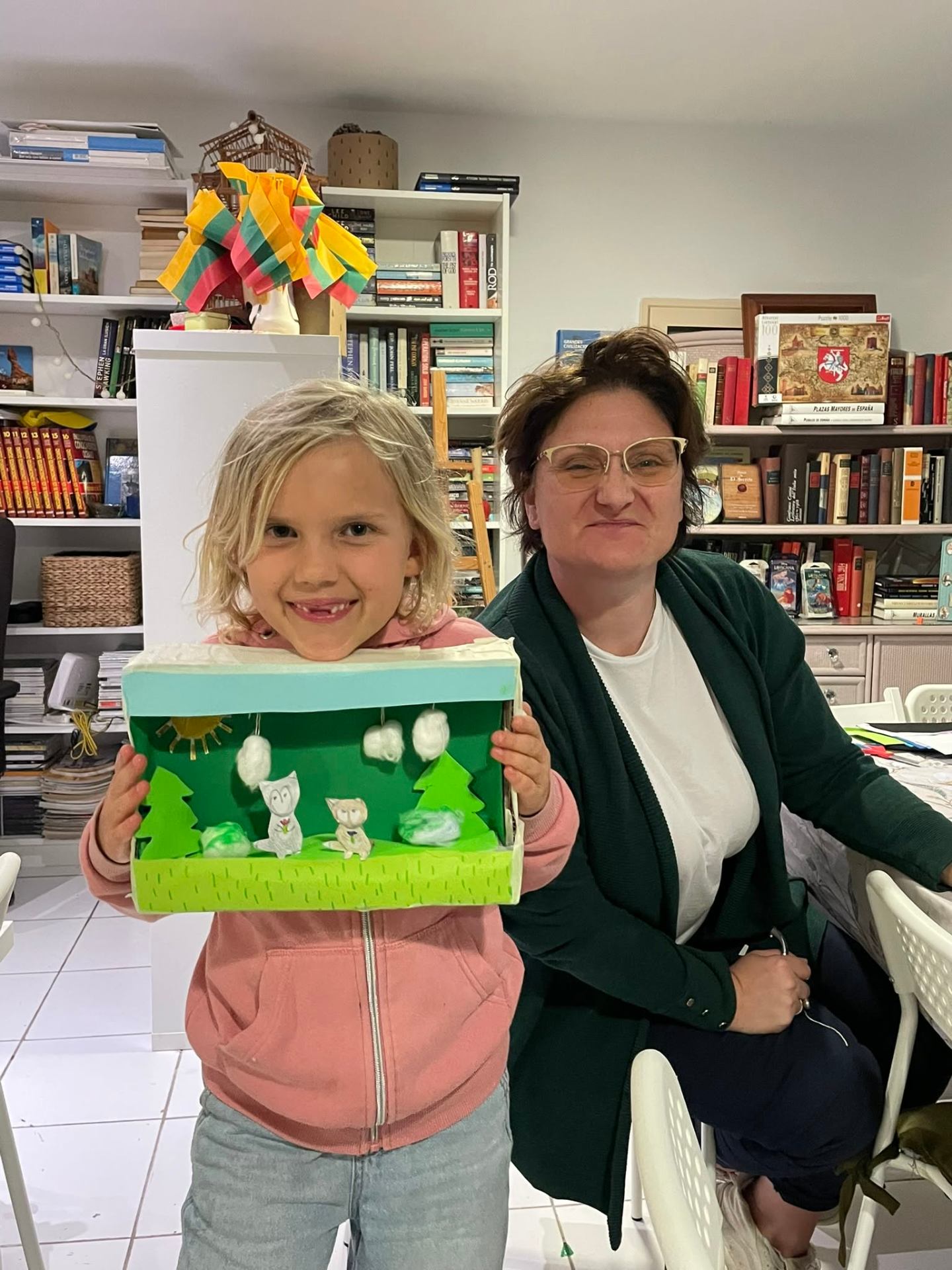 Child showing finished diorama with the workshop host