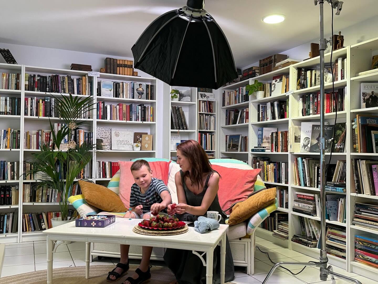 Mother and son enjoying strawberries on the library sofa